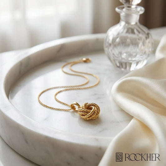 14K Yellow Gold Cable Chain with Love Knot Pendant, 18 Inch, on marble vanity tray with silk