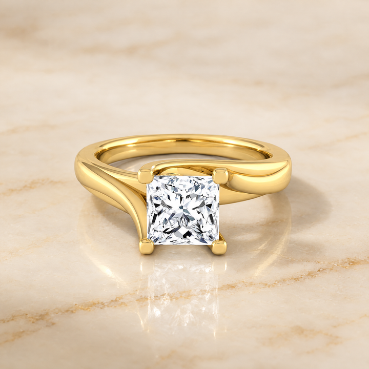 The Joplin Twisted Bypass Solitaire Princess Cut Engagement Ring Setting in 18K Yellow Gold