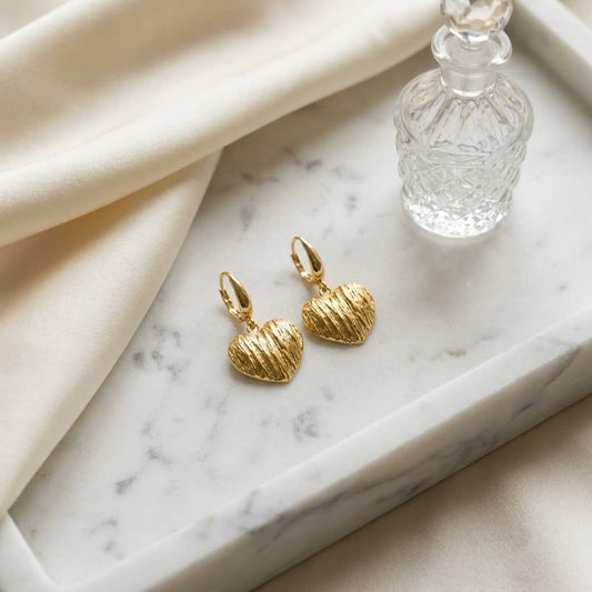 14K Yellow Gold Textured Heart Drop Earrings, on marble vanity tray with silk