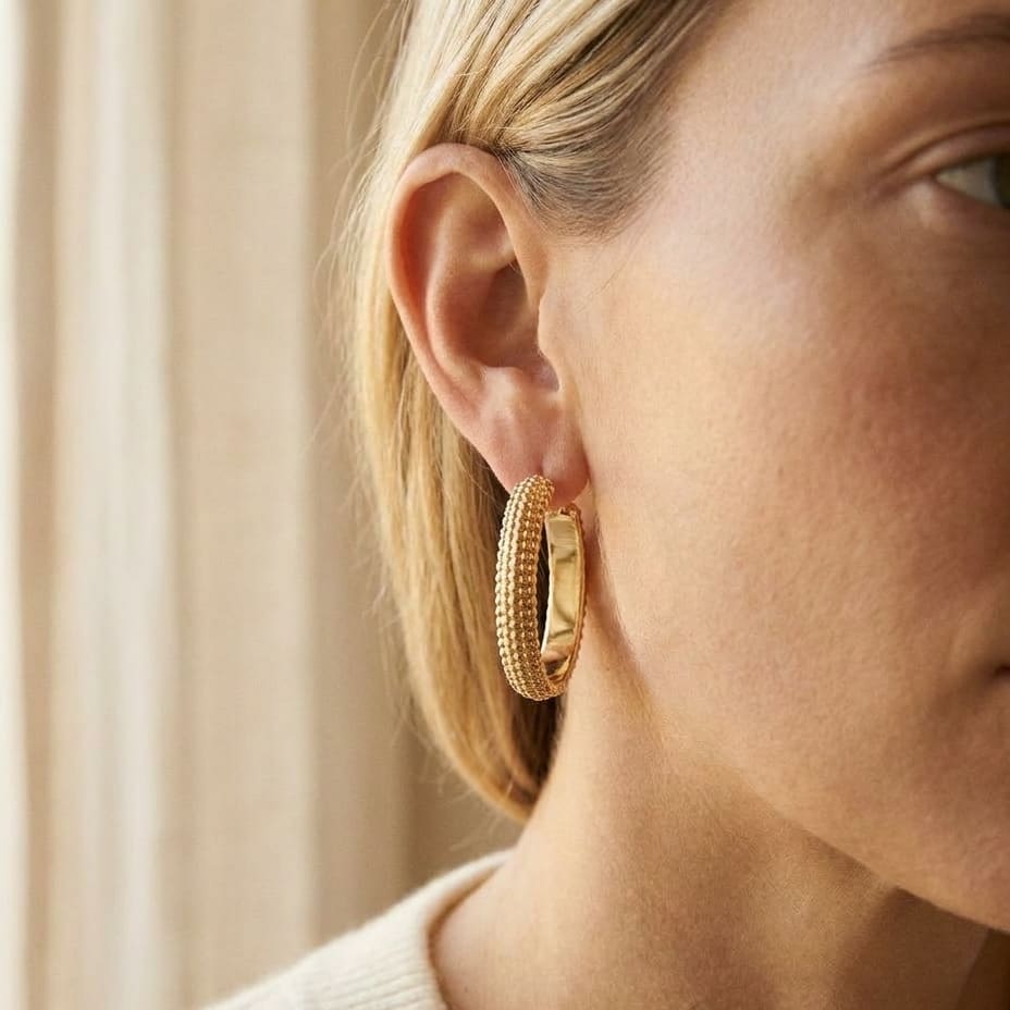 14K Yellow Gold Beaded Oval Hoop Earrings, worn close-up portrait