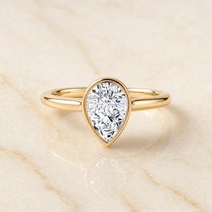 The Duran Simple Bezel Solitaire Pear Engagement Ring Setting in 18K Yellow Gold