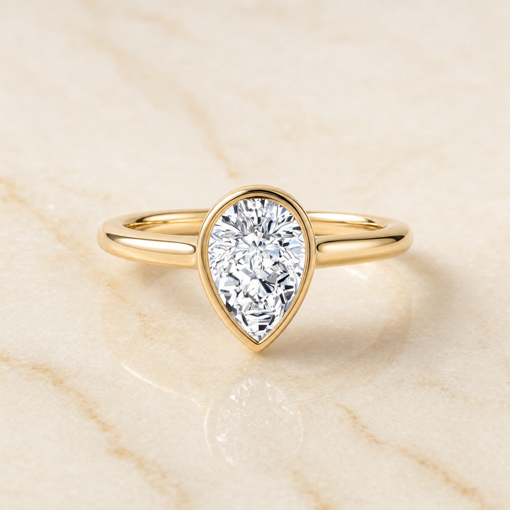 The Duran Simple Bezel Solitaire Pear Engagement Ring Setting in 18K Yellow Gold