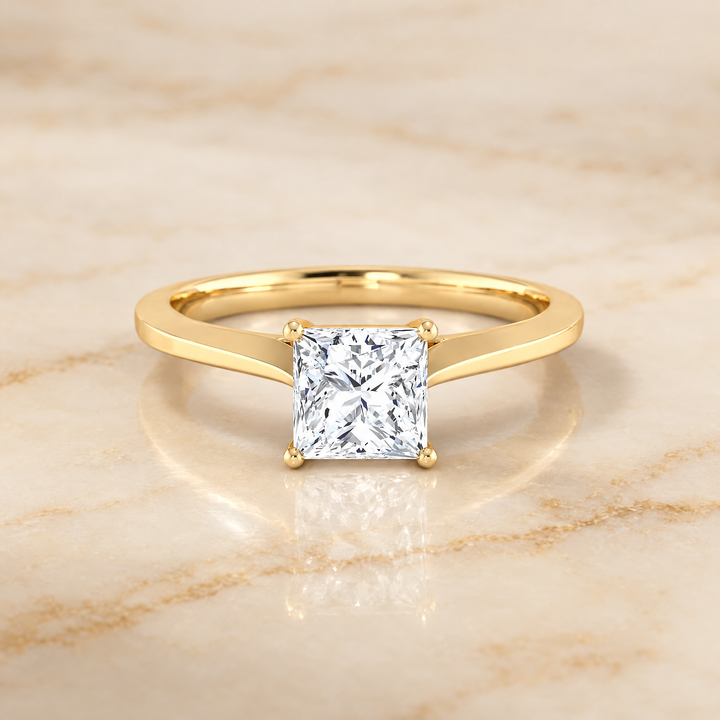 The Elena Timeless Graduated Beveled Shank Solitaire Princess Cut Engagement Ring Setting in 18K Yellow Gold