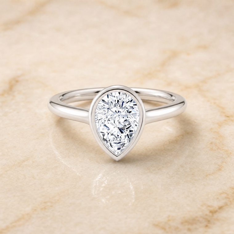 The Duran Simple Bezel Solitaire Pear Engagement Ring Setting in 18K White Gold