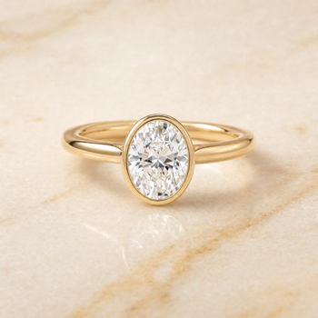 The Duran Simple Bezel Solitaire Oval Engagement Ring Setting in 18K Yellow Gold
