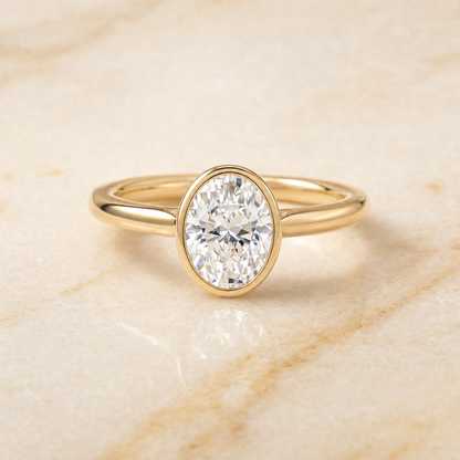 The Duran Simple Bezel Solitaire Oval Engagement Ring Setting in 18K Yellow Gold