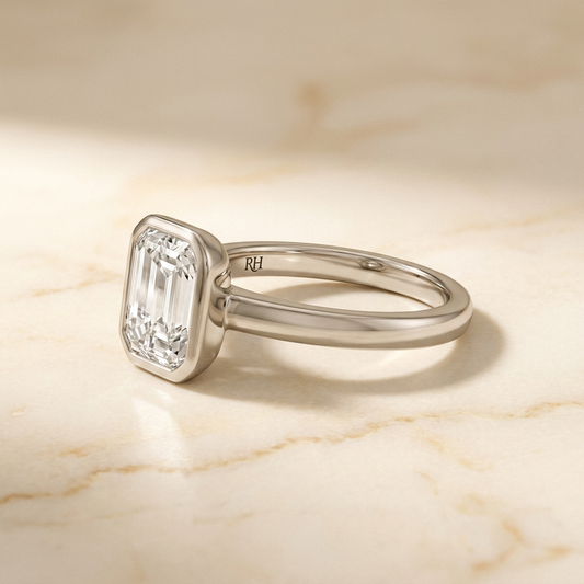 The Agnes bezel solitaire emerald cut engagement ring setting in 18k white gold — alt-angle hero — RockHer