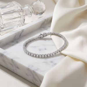 Diamond 4-prong Tennis Bracelet in 18K White Gold, on marble vanity tray with silk
