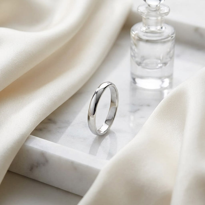 3mm Slightly Domed Traditional Oval Wedding Band in 18K White Gold, on marble vanity tray with silk