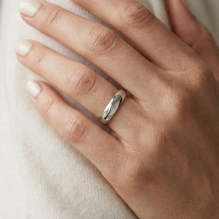 4mm Slightly Domed Traditional Oval Wedding Band in 18K White Gold, worn on hand, close-up