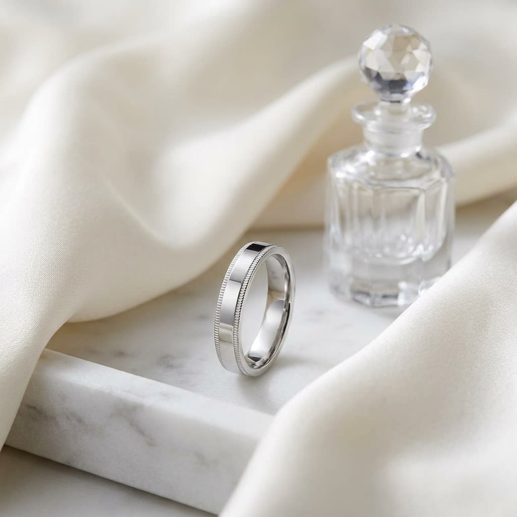 4mm Flat Milgrain Comfort-Fit Wedding Band in 18K White Gold, on marble vanity tray with silk