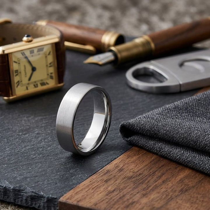 6mm Satin Finish Carved Wedding Band in 18K White Gold, on walnut surface with pocket square