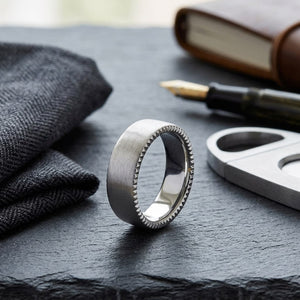 7.5mm Satin Finish Carved Wedding Band in 18K White Gold, on walnut surface with pocket square