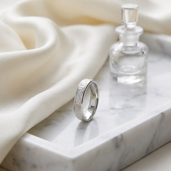 4mm Hammered Finish Carved Wedding Band in 18K White Gold, on marble vanity tray with silk