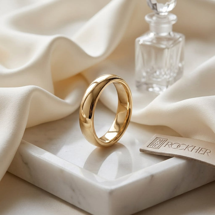 4mm Slightly Domed Traditional Oval Wedding Band in 18K Yellow Gold, on marble vanity tray with silk