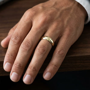 6mm Slightly Domed Traditional Oval Wedding Band in 18K Yellow Gold, worn on hand, masculine close-up