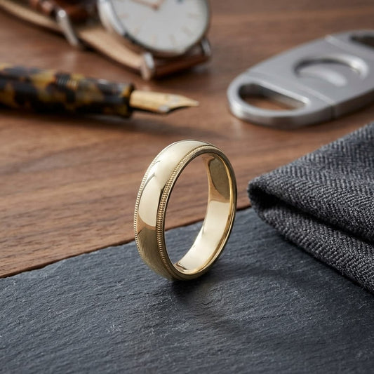 5mm Slightly Domed Traditional Oval Milgrain Wedding Band in 18K Yellow Gold, on walnut surface with pocket square
