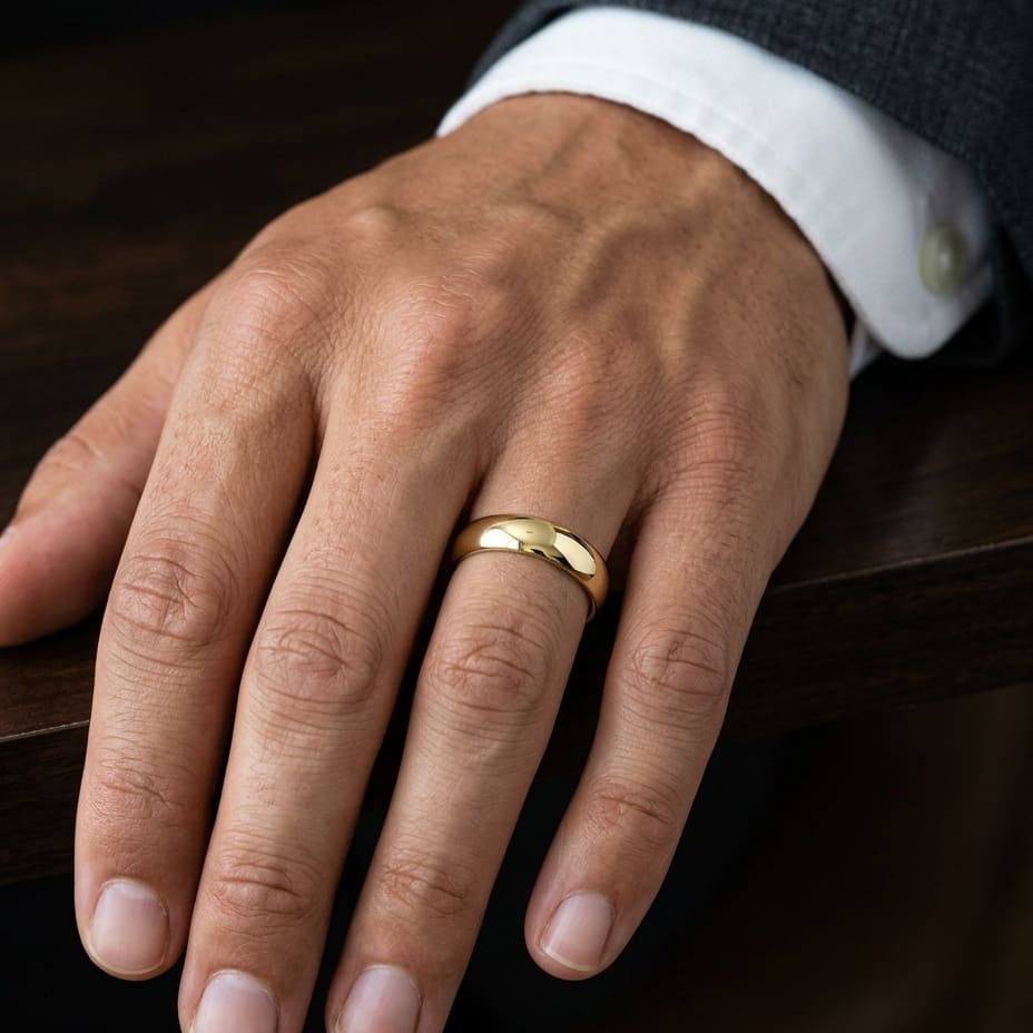 6mm High Dome Comfort-Fit Wedding Band in 18K Yellow Gold, worn on hand, masculine close-up