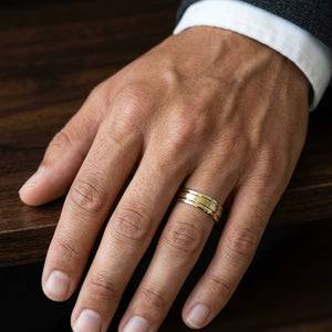 6mm Satin Finish Parallel Groove Carved Wedding Band in 18K Yellow Gold, worn on hand, masculine close-up