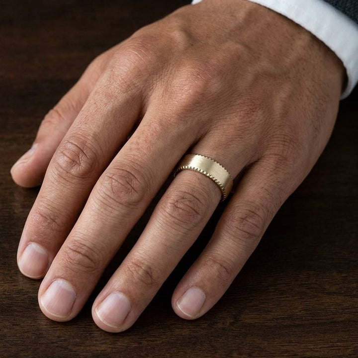 7.5mm Satin Finish Carved Wedding Band in 18K Yellow Gold, worn on hand, masculine close-up
