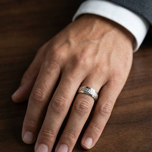7.5mm Hammered Finish Beveled Edge Carved Wedding Band in 18K Yellow Gold, worn on hand, masculine close-up