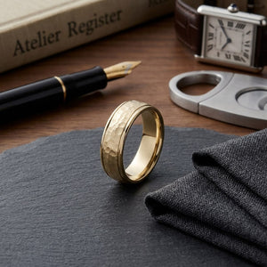 6mm Hammered Finish Carved Wedding Band in 18K Yellow Gold, on walnut surface with pocket square
