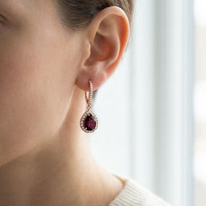 Rhodolite Garnet And Diamond Teardrop Halo Dangling Earrings in 14K Rose Gold, worn close-up portrait