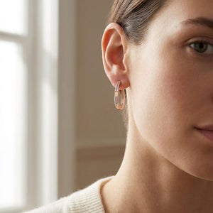 Diamond Pave Linear Oval Hoop Earrings With High Polish Accent in 14K Rose Gold, worn close-up portrait