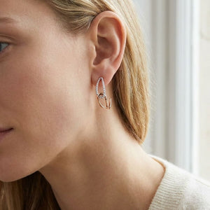 Diamond Pave And High Polish Teardrop Interlink Earrings in 14K Rose Gold, worn close-up portrait