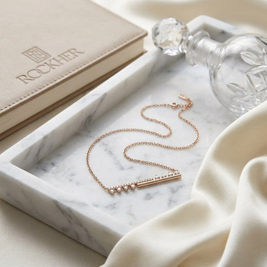 Diamond Half-bar And Pave Necklace With Prong-set Accents in 14K Rose Gold, on marble vanity tray with silk
