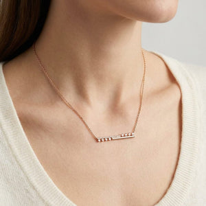 Diamond Half-bar And Pave Necklace With Prong-set Accents in 14K Rose Gold, worn close-up portrait