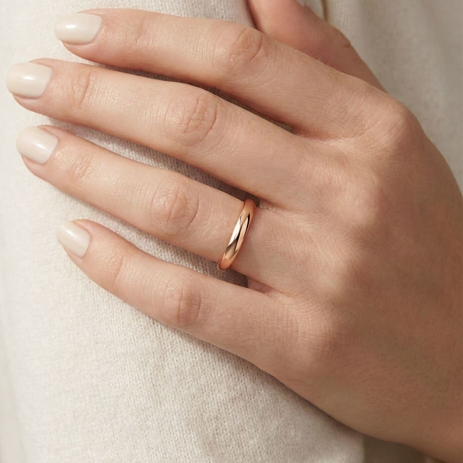 2mm Slightly Domed Traditional Oval Wedding Band in 14K Rose Gold, worn on hand, close-up