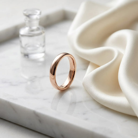 2.5mm Slightly Domed Traditional Oval Wedding Band in 14K Rose Gold, on marble vanity tray with silk