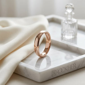 3mm Slightly Domed Traditional Oval Wedding Band in 14K Rose Gold, on marble vanity tray with silk