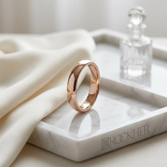 3mm Slightly Domed Traditional Oval Wedding Band in 14K Rose Gold, on marble vanity tray with silk