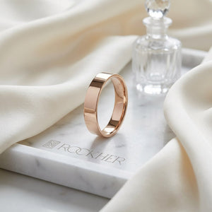 4mm Flat Comfort-Fit Wedding Band in 14K Rose Gold, on marble vanity tray with silk