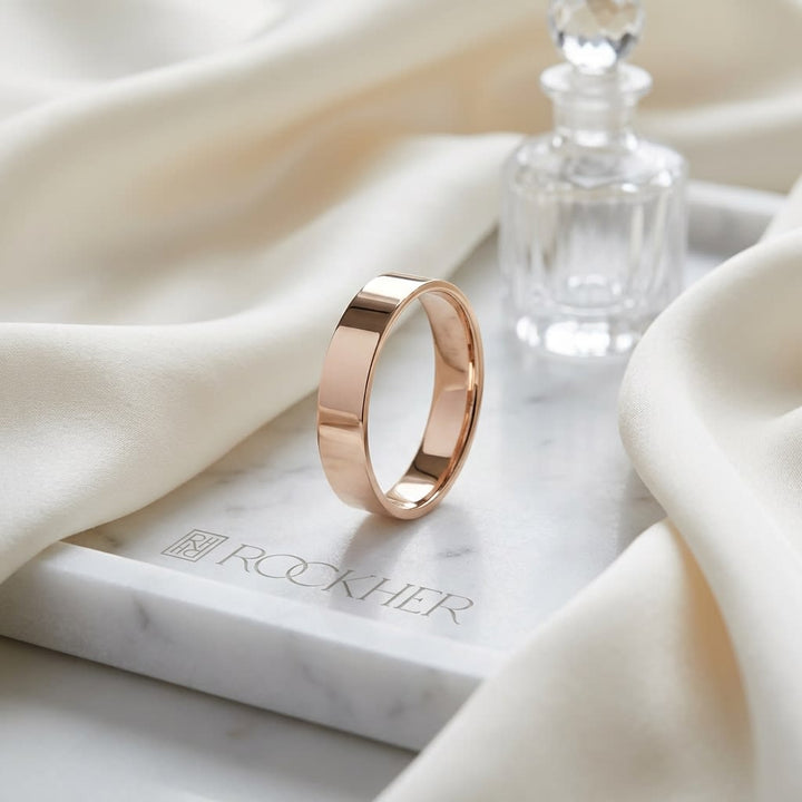 4mm Flat Comfort-Fit Wedding Band in 14K Rose Gold, on marble vanity tray with silk