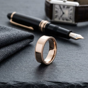 8mm Flat Milgrain Comfort-Fit Wedding Band in 14K Rose Gold, on walnut surface with pocket square