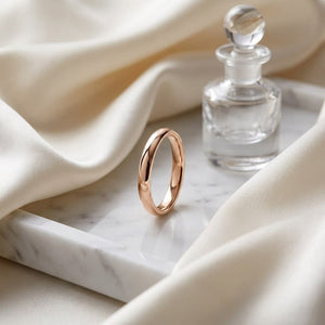 3mm Slightly Domed Comfort-Fit Wedding Band in 14K Rose Gold, on marble vanity tray with silk