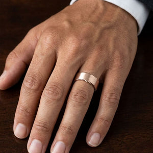 7.5mm Satin Finish Carved Wedding Band in 14K Rose Gold, worn on hand, masculine close-up