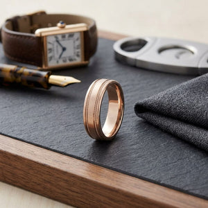 7.5mm Satin Finish Rope Carved Wedding Band in 14K Rose Gold, on walnut surface with pocket square
