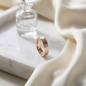 4mm Satin Finish High Polished Round Edge Carved Wedding Band in 14K Rose Gold, on marble vanity tray with silk