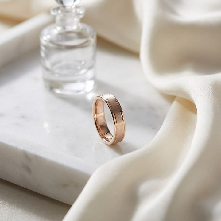 4mm Satin Finish High Polished Round Edge Carved Wedding Band in 14K Rose Gold, on marble vanity tray with silk