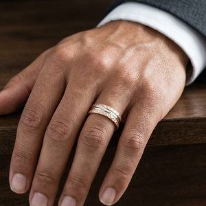 7.5mm Hammered Finish Carved Wedding Band in 14K Rose Gold, worn on hand, masculine close-up