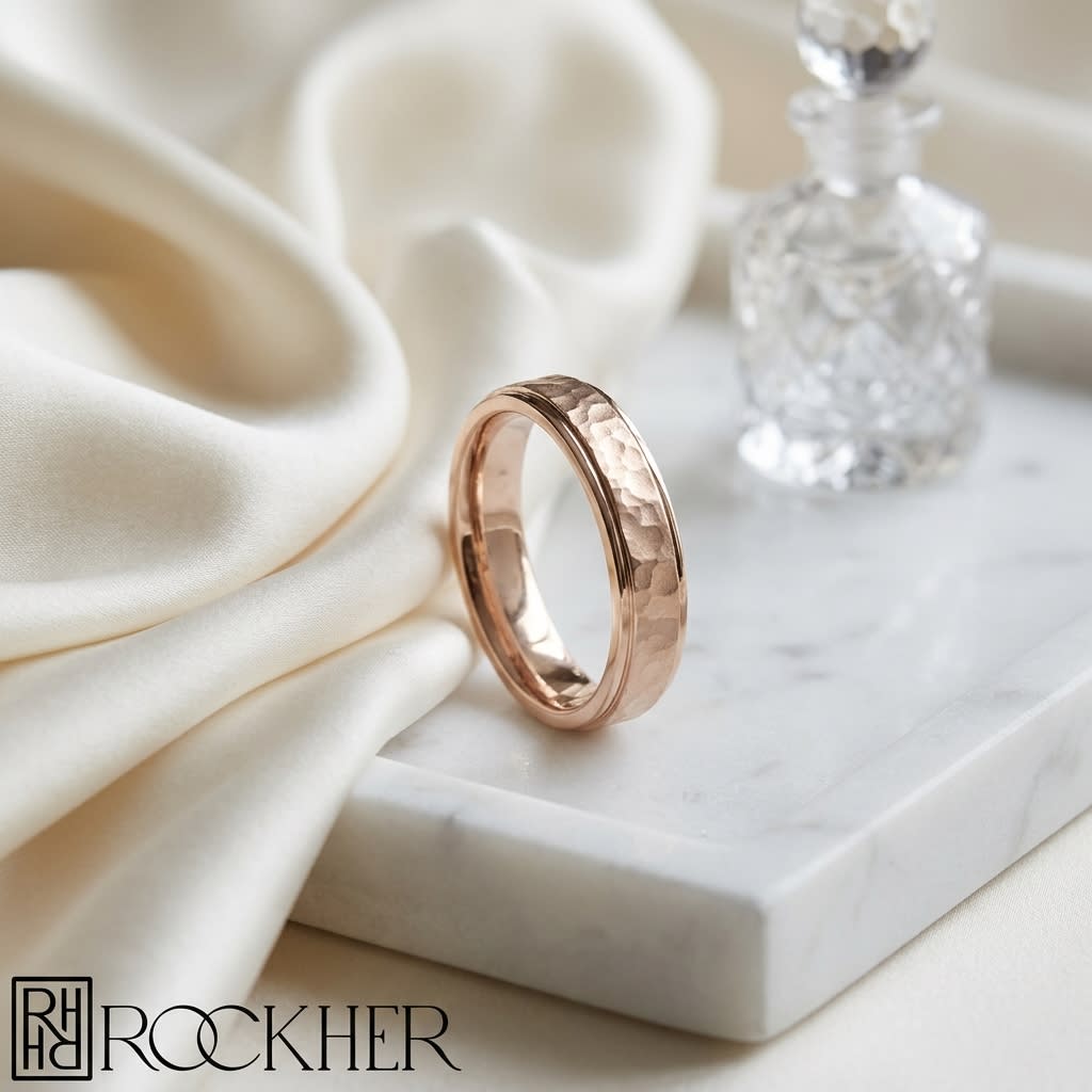 4mm Hammered Finish Carved Wedding Band in 14K Rose Gold, on marble vanity tray with silk