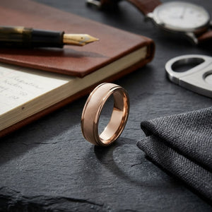 7mm Florentine Center High Polish Round Edge Carved Wedding Band in 14K Rose Gold, on walnut surface with pocket square