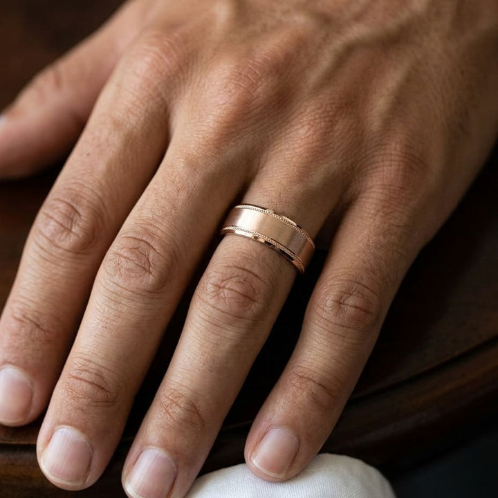8mm Satin Finish Carved Wedding Band in 14K Rose Gold, worn on hand, masculine close-up