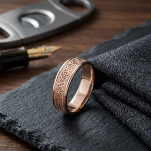 6mm Celtic Knot Carved Wedding Band in 14K Rose Gold, on walnut surface with pocket square