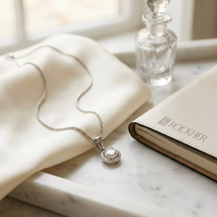 Diamond Halo Pendant in 14K White Gold, on marble vanity tray with silk