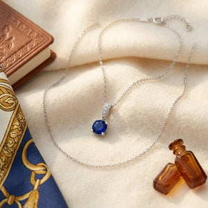 Sapphire Round Solitaire Pendant with Diamond Bail in 14K White Gold - flat lay